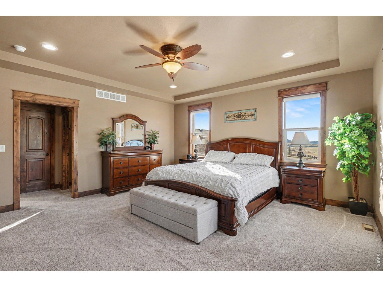 10723 Buckhorn Ridge Way Loveland, CO 80538 - Photo 19 of 50 a spacious bedroom with a large bed and a chandelier