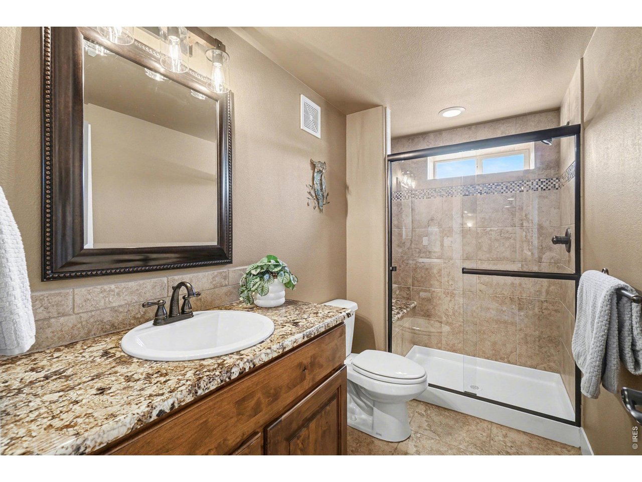 10723 Buckhorn Ridge Way Loveland, CO 80538 - Photo 26 of 50 a bathroom with a granite countertop sink toilet a mirror and shower