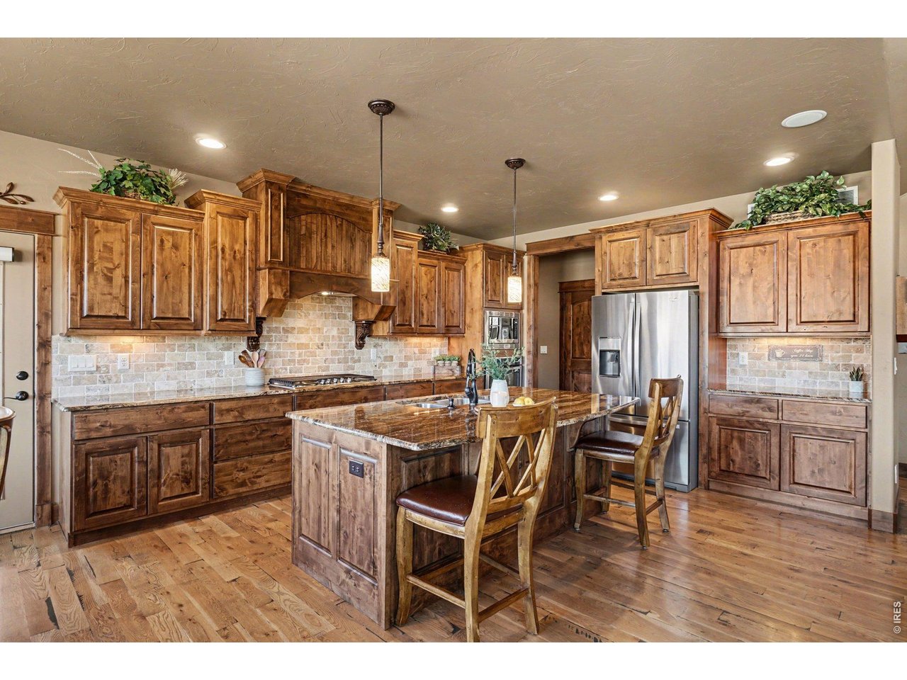 10723 Buckhorn Ridge Way Loveland, CO 80538 - Photo 10 of 50 a kitchen with kitchen island granite countertop a table chairs sink and cabinets