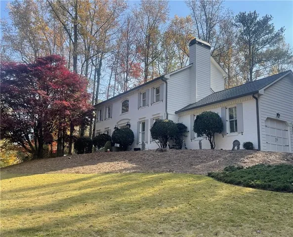 a view of a house with a yard patio and tree