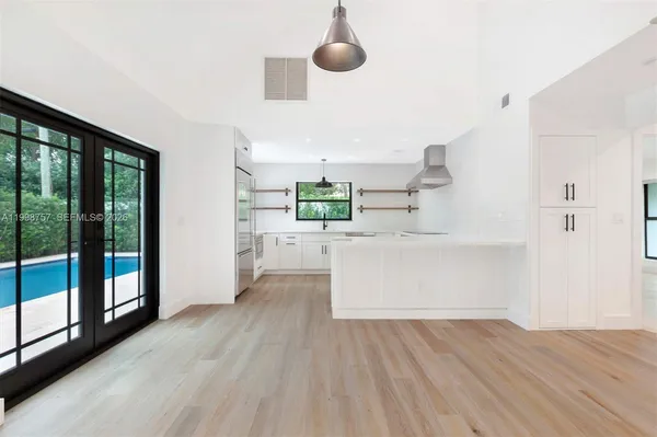 a large white kitchen with wooden floor