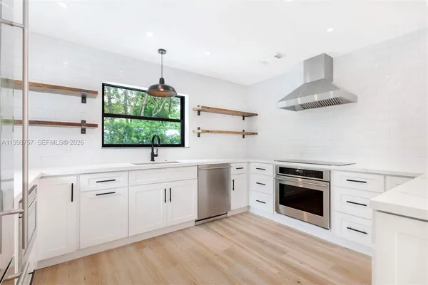 a kitchen with stainless steel appliances a stove and a chandelier