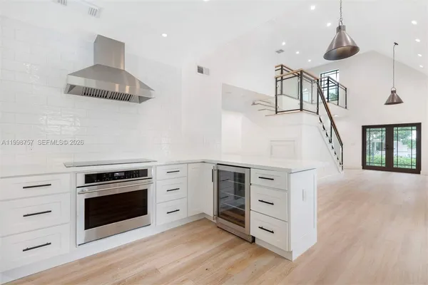 a kitchen with stainless steel appliances a sink a stove and cabinets