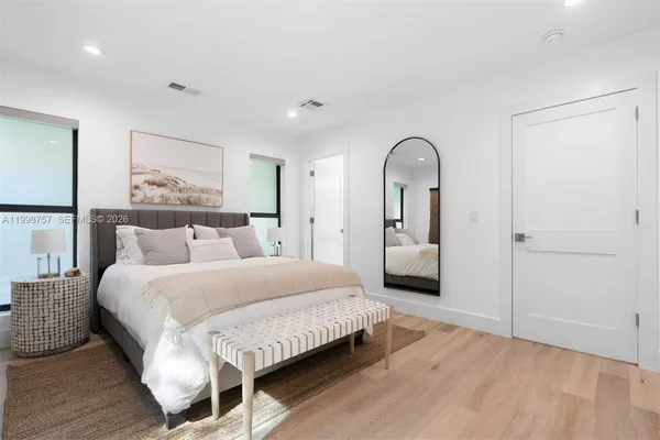a bedroom with a large bed and a painting on the wall