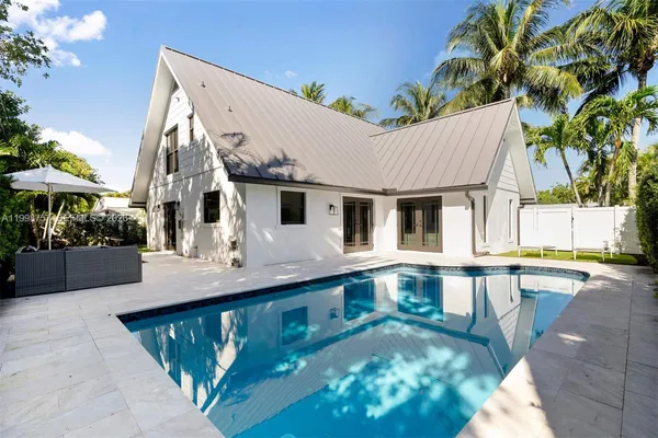 a view of pool with two chairs in patio