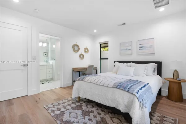 a spacious bedroom with a bed and painting on the wall