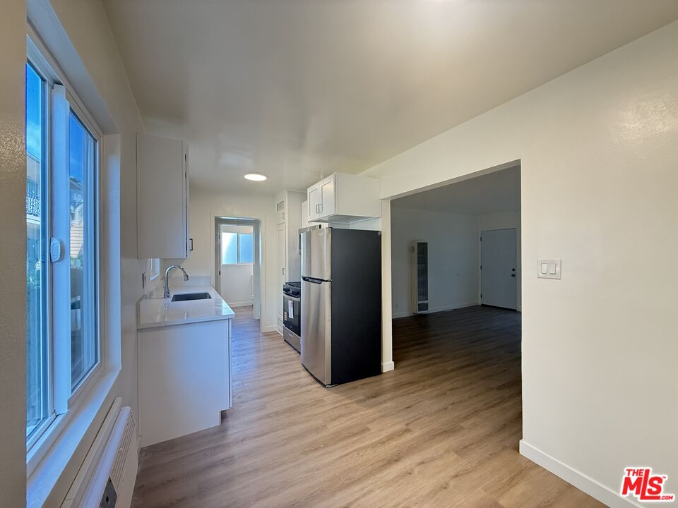 1314 10th Street, Unit A Santa Monica, CA 90401 - Photo 13 of 53 a view of a refrigerator in kitchen and wooden floor