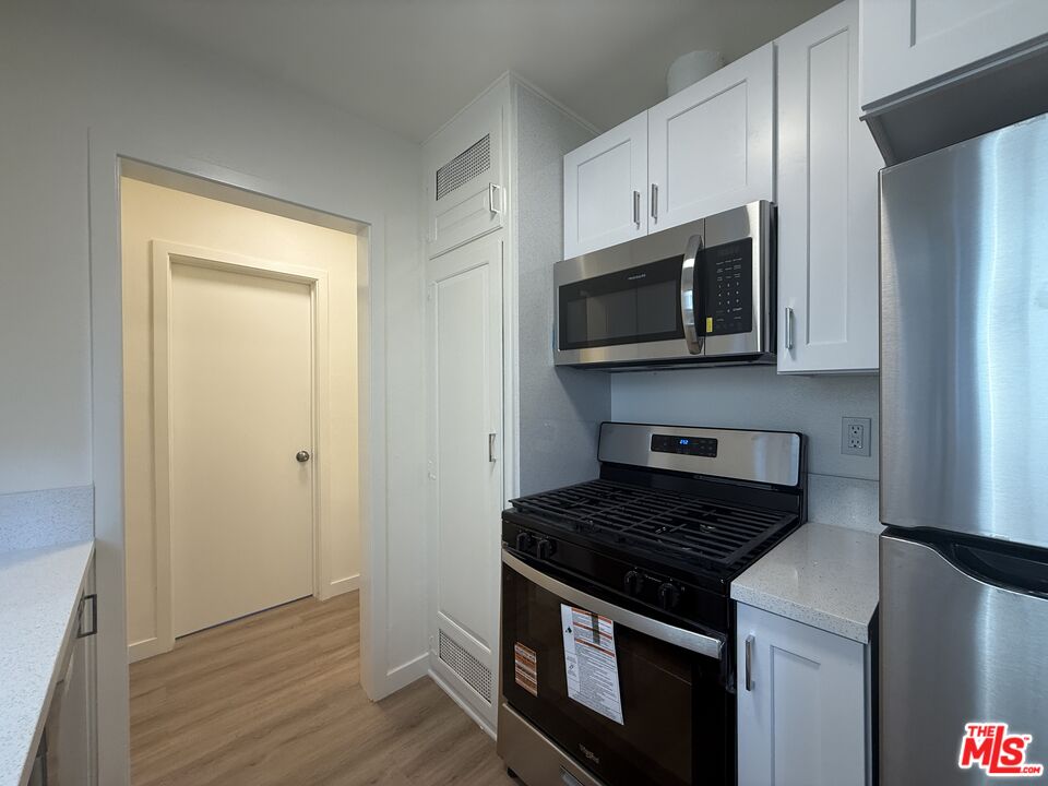 1314 10th Street, Unit A Santa Monica, CA 90401 - Photo 14 of 53 a kitchen with stainless steel appliances a stove a microwave and cabinets