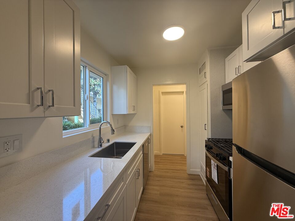 1314 10th Street, Unit A Santa Monica, CA 90401 - Photo 15 of 53 a kitchen with granite countertop a sink and a stove top oven