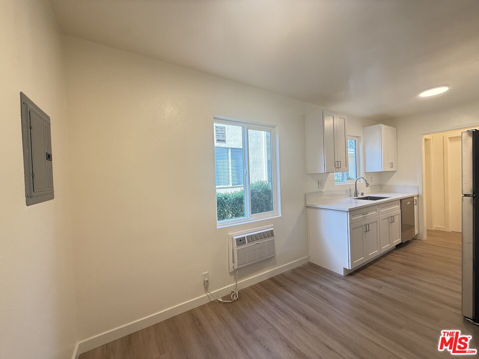 1314 10th Street, Unit A Santa Monica, CA 90401 - Photo 21 of 53 a kitchen with wooden floors and white cabinets