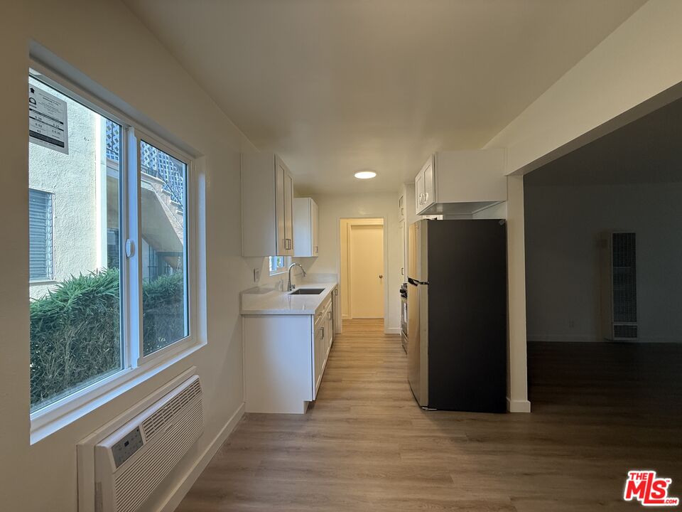 1314 10th Street, Unit A Santa Monica, CA 90401 - Photo 10 of 53 a view of a kitchen with refrigerator and wooden floor
