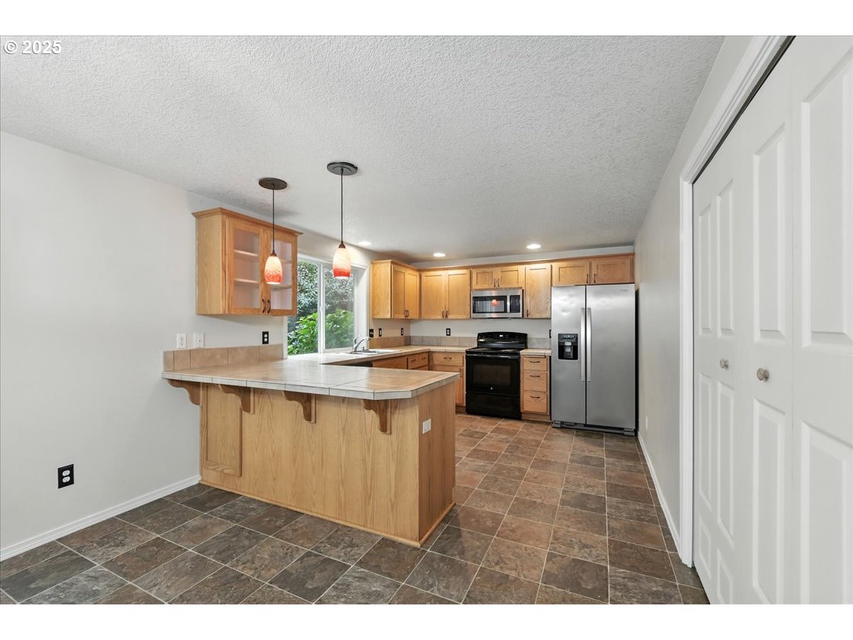 3044 South 3rd Way Ridgefield, WA 98642 - Photo 11 of 34 a kitchen with granite countertop a sink cabinets stainless steel appliances and a window