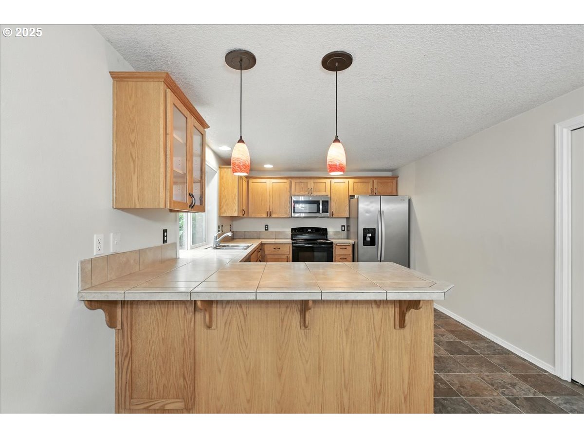 3044 South 3rd Way Ridgefield, WA 98642 - Photo 12 of 34 a kitchen with kitchen island a sink stainless steel appliances and a chandelier