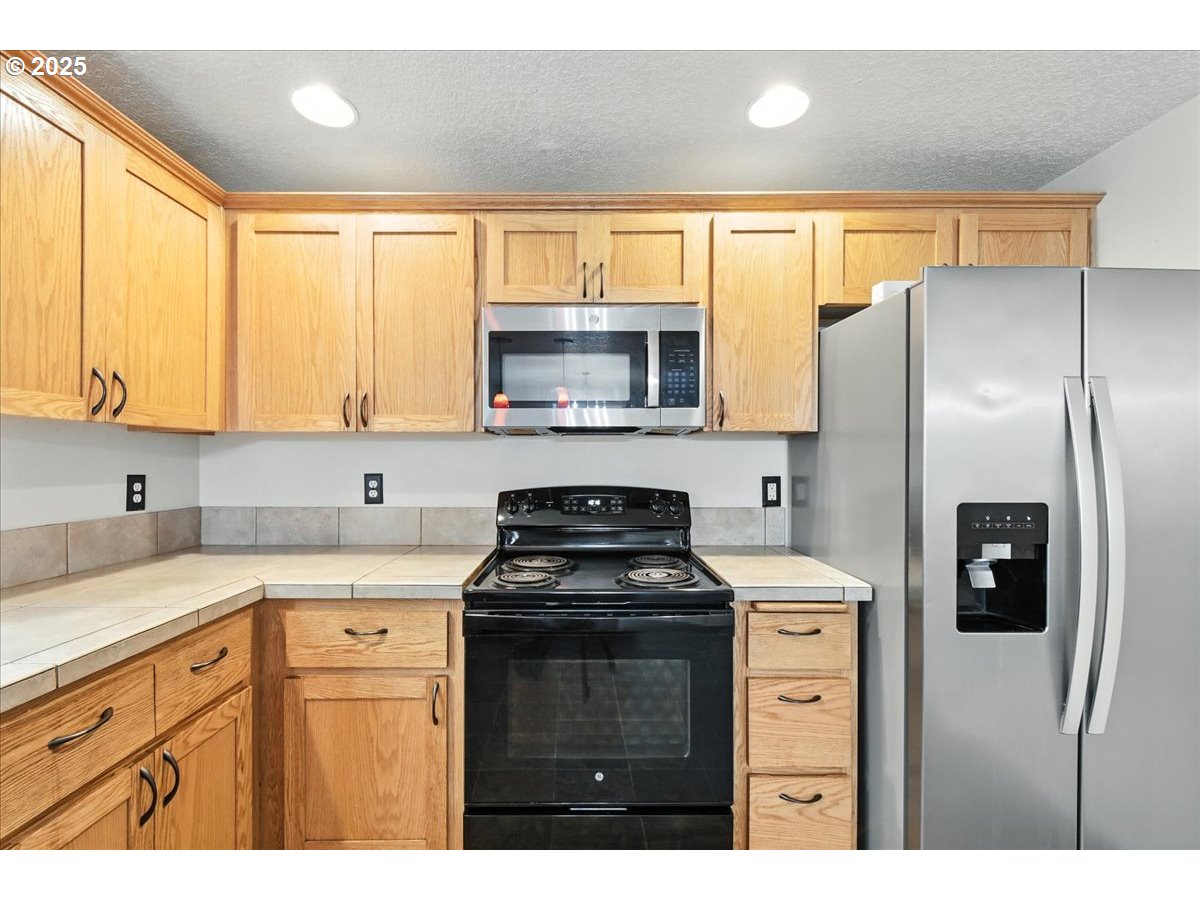 3044 South 3rd Way Ridgefield, WA 98642 - Photo 14 of 34 a kitchen with stainless steel appliances a stove sink microwave and refrigerator