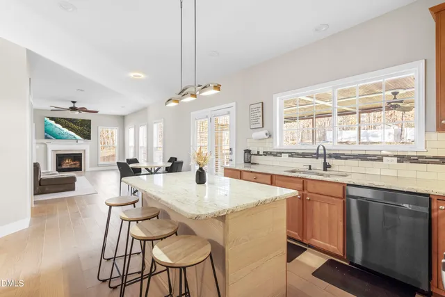 a living room with furniture a fireplace and a large window