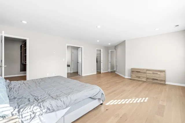 a spacious bedroom with a bed and a chandelier