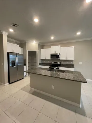a large kitchen with stainless steel appliances lots of counter top space