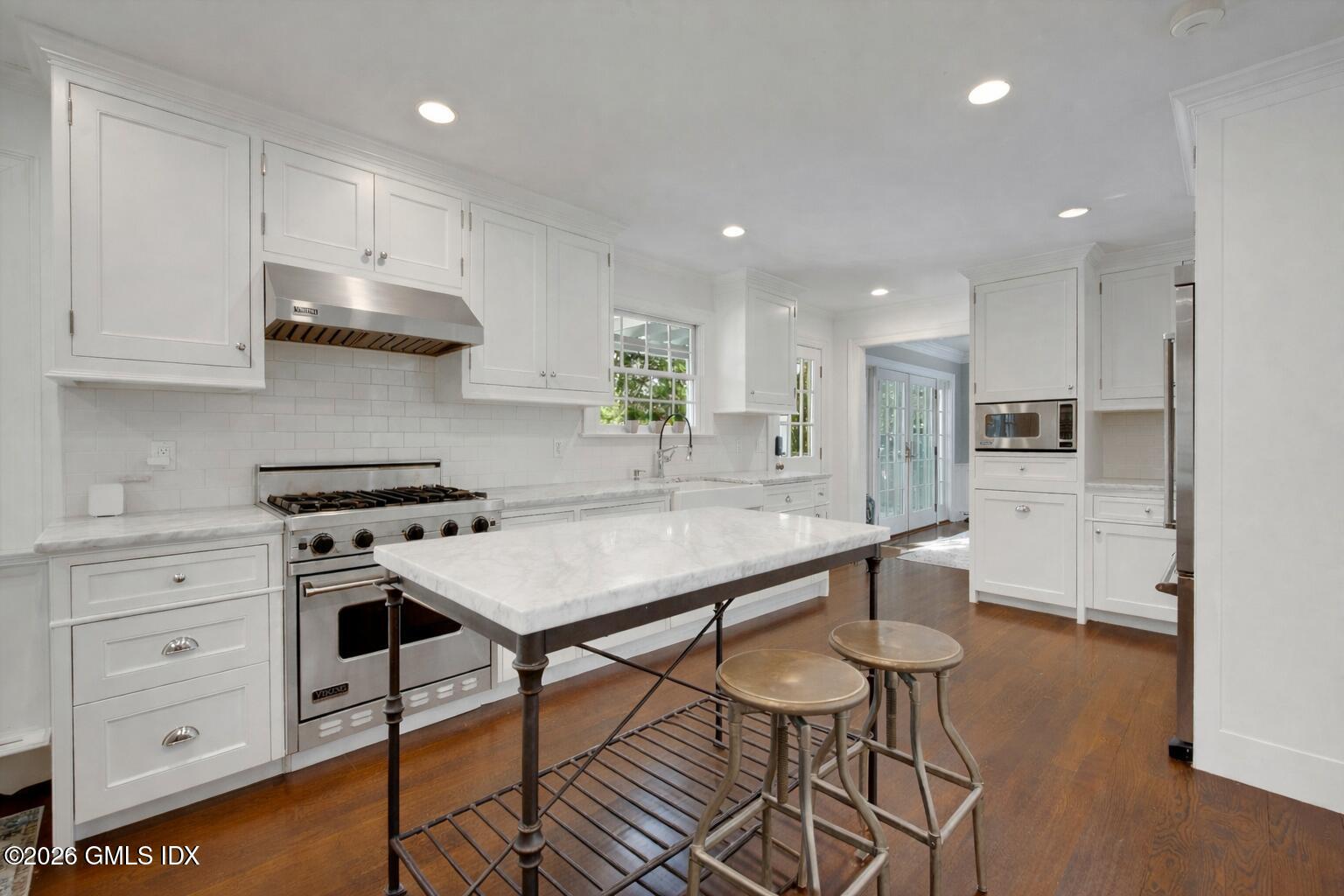 98 Hillcrest Park Road Cos Cob, CT 06807 - Photo 8 of 27 a kitchen with stainless steel appliances a table chairs refrigerator and sink