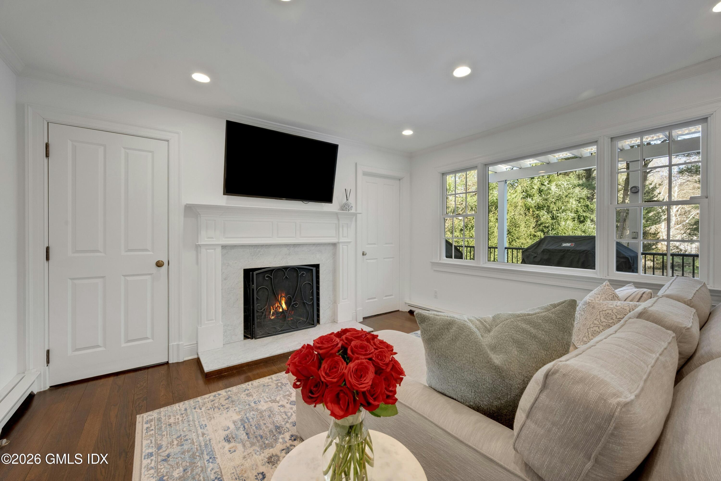 98 Hillcrest Park Road Cos Cob, CT 06807 - Photo 10 of 27 a living room with furniture a flat screen tv and a fireplace