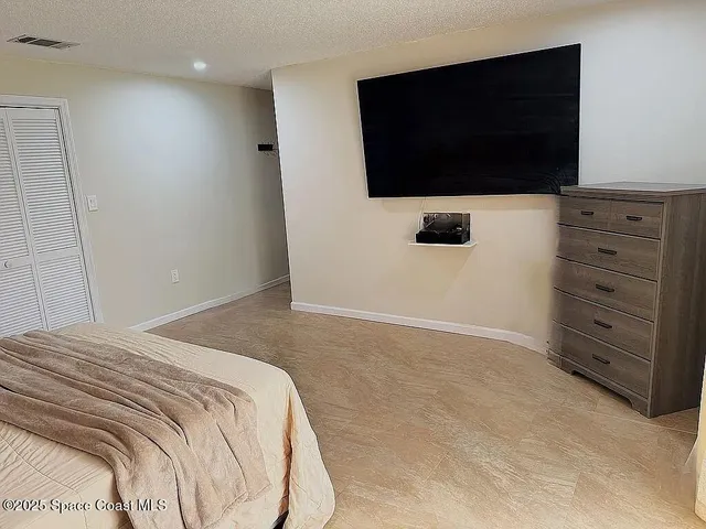 a bedroom with a bed and a television