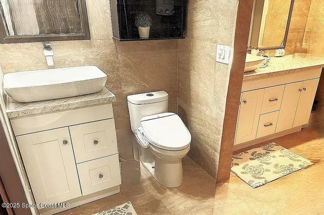 a bathroom with a toilet sink and mirror