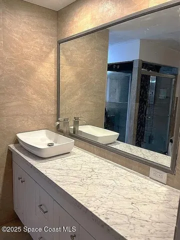a bathroom with a granite countertop sink and a mirror