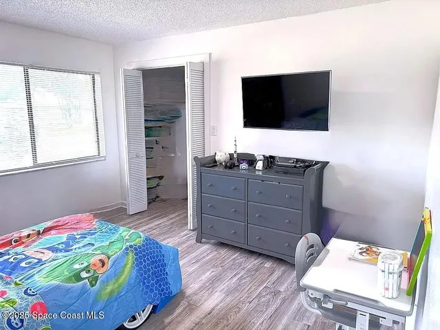 a bedroom with a bed and flat screen tv