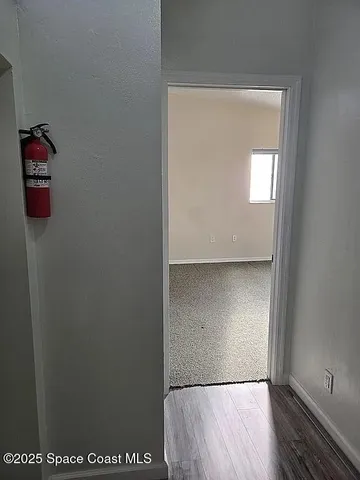 an empty room with sliding door and wooden floor