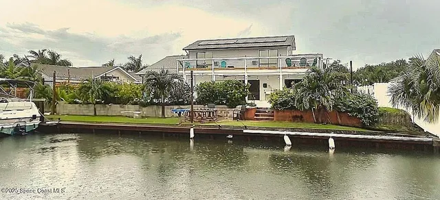 a view of a house with a large pool plants and large trees