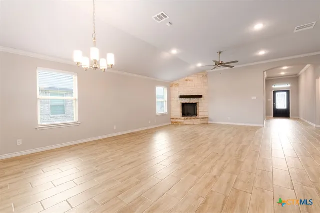 a view of a livingroom with a chandelier fan and wooden floor