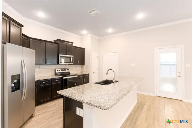 a kitchen with stainless steel appliances granite countertop a sink stove and refrigerator