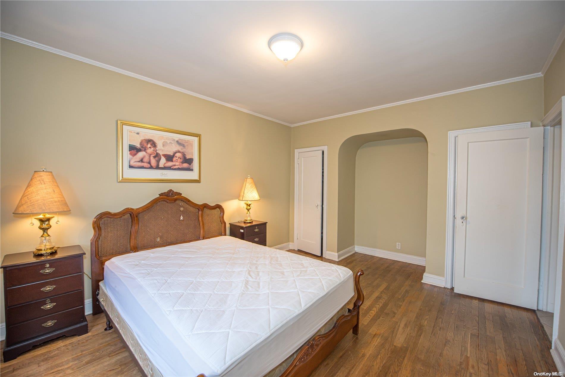 53-15 37th Road Queens, NY 11377 - Photo 12 of 25 a bed room with a bed and a night stand