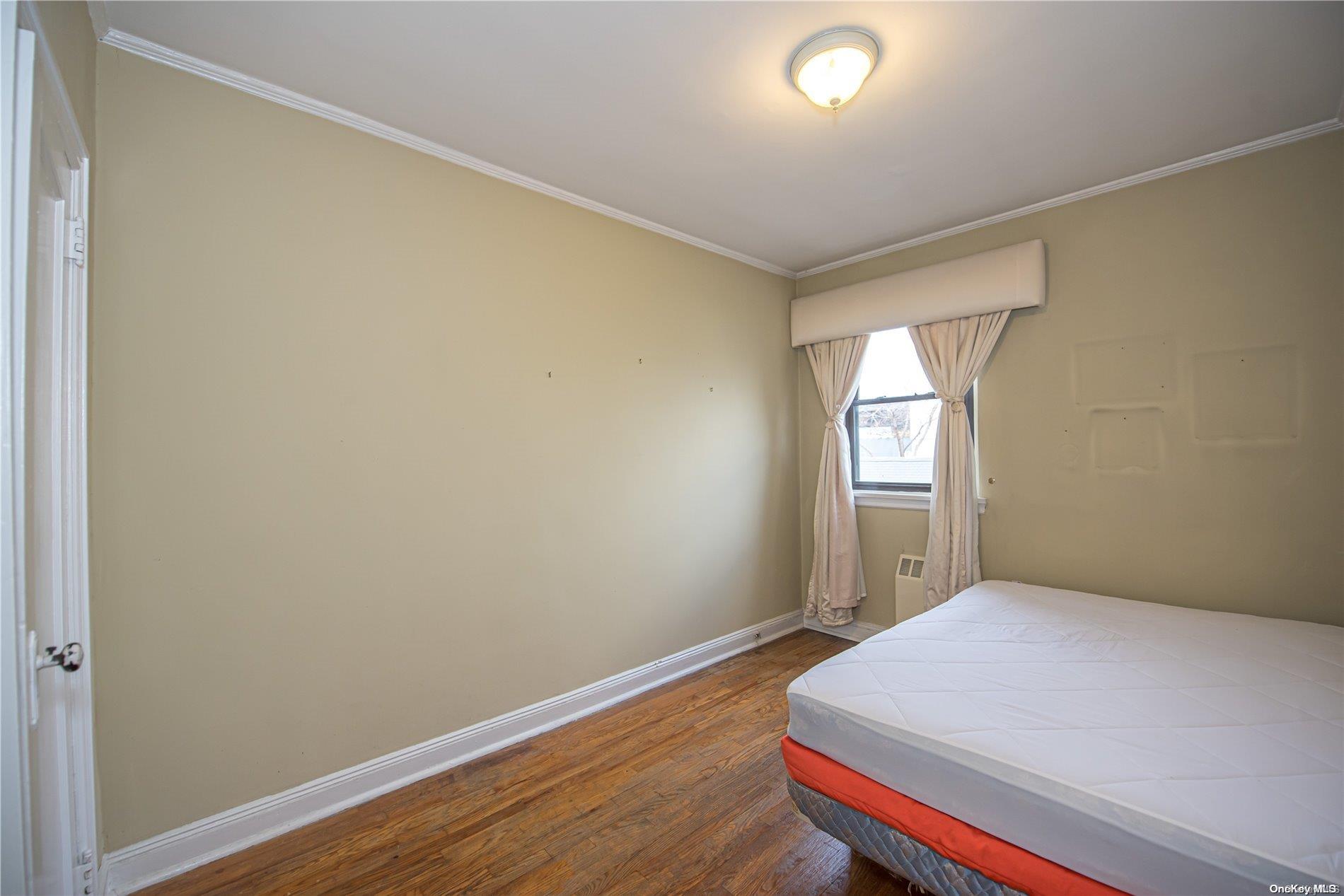 53-15 37th Road Queens, NY 11377 - Photo 14 of 25 a bedroom with a bed and a window