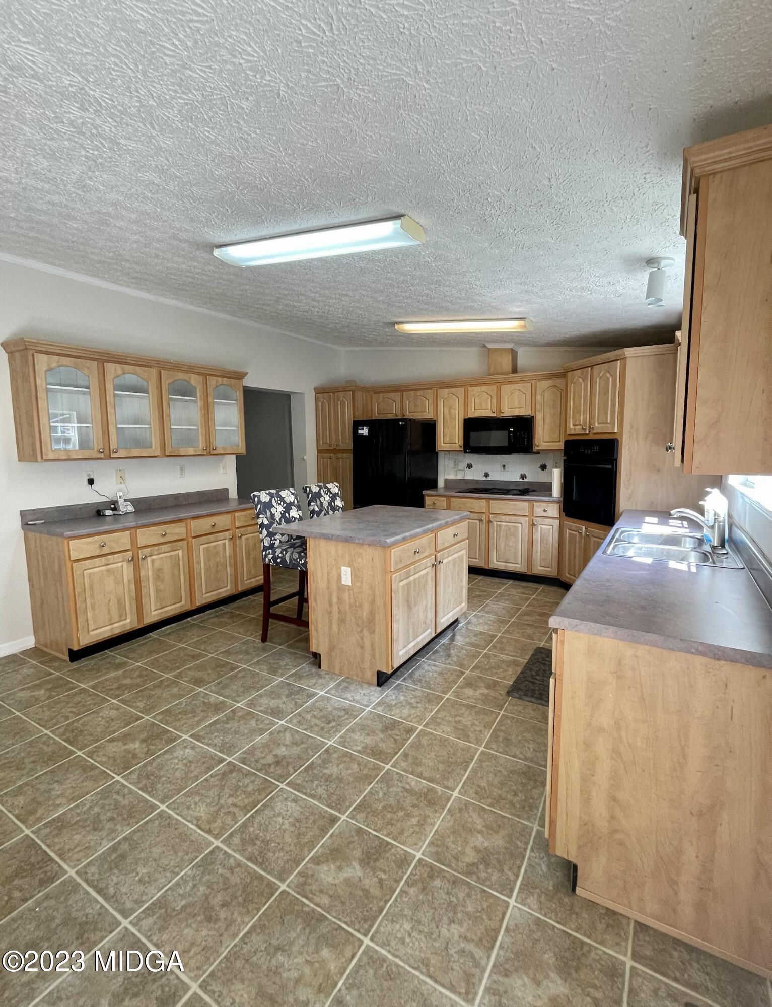 1222 Lassiter Road Forsyth, GA 31029 - Photo 2 of 6 a large white kitchen with a stove a sink and a microwave