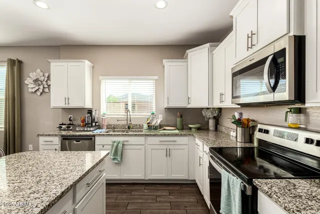 a kitchen with stainless steel appliances granite countertop a stove sink microwave and cabinets