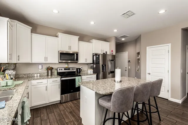 a kitchen with a table chairs microwave and cabinets