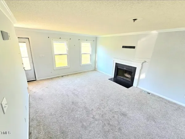 a view of empty room with a fireplace