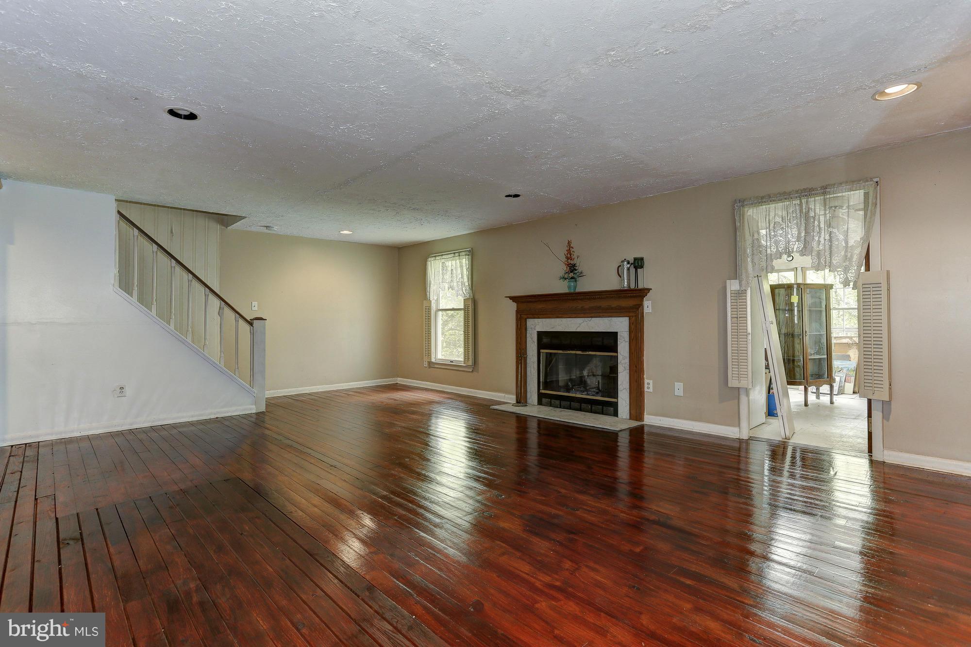 2634 Ridge Road Baltimore, MD 21244 - Photo 3 of 13 a view of empty room with wooden floor and fireplace