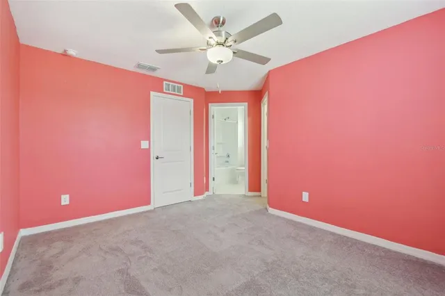 a view of an empty room with a ceiling fan