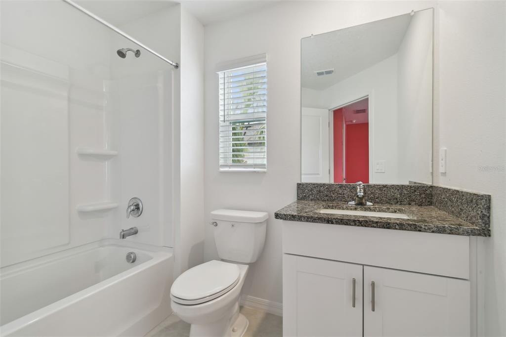 36390 Wl Hl Way Zephyrhills, FL 33541 - Photo 31 of 77 a bathroom with a granite countertop sink a toilet and shower