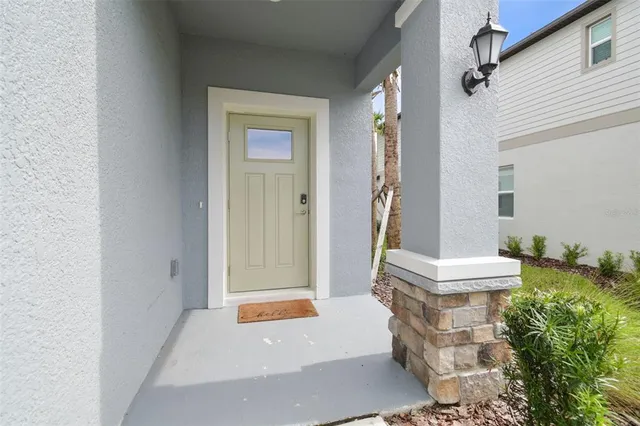 a view of a hallway with granite countertop a couch and chandelier