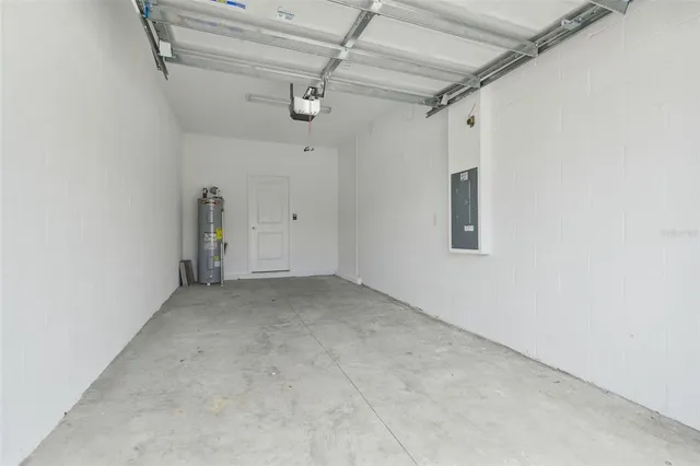 a view of an empty room with chandelier fan and a window