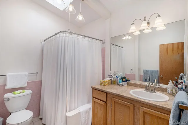 a bathroom with a toilet a sink and a mirror