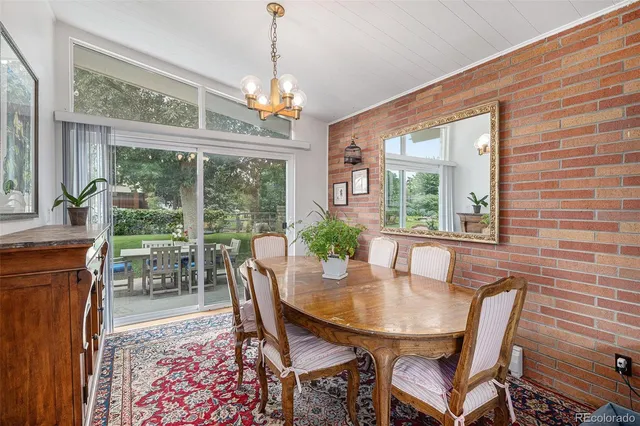 a dining room with furniture a chandelier and wooden floor