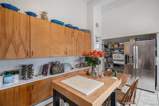a kitchen with stainless steel appliances a table chairs and a refrigerator