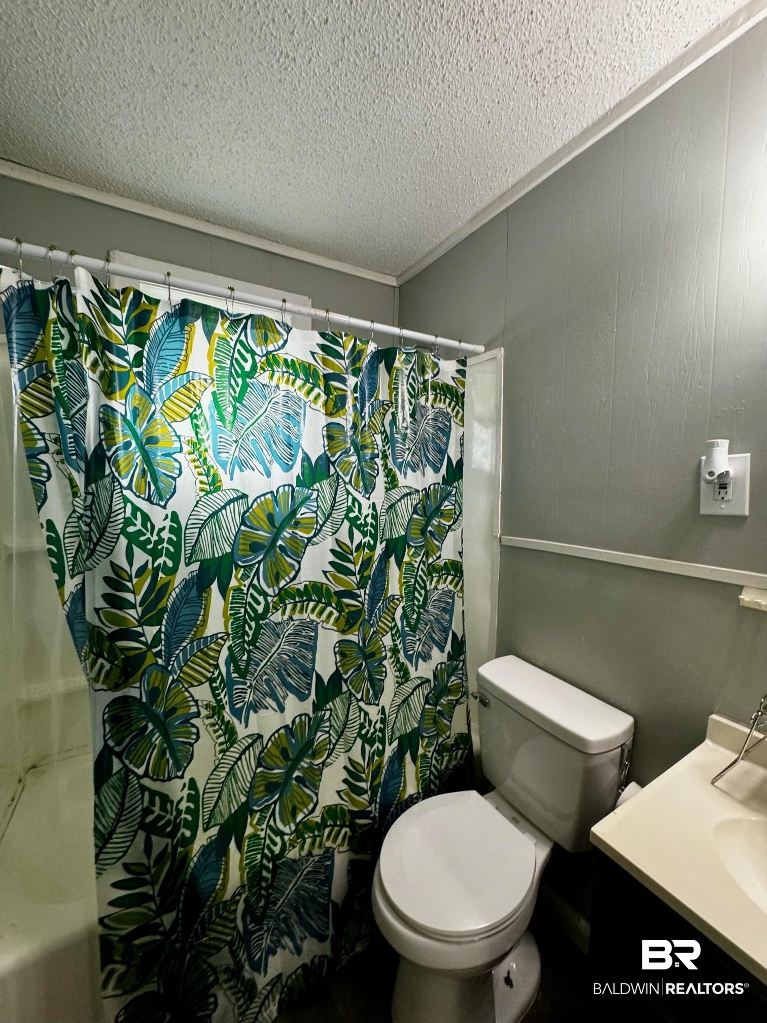 502 Forest Street Mobile, AL 36611 - Photo 5 of 10 Bathroom featuring vanity, a textured ceiling, and toilet