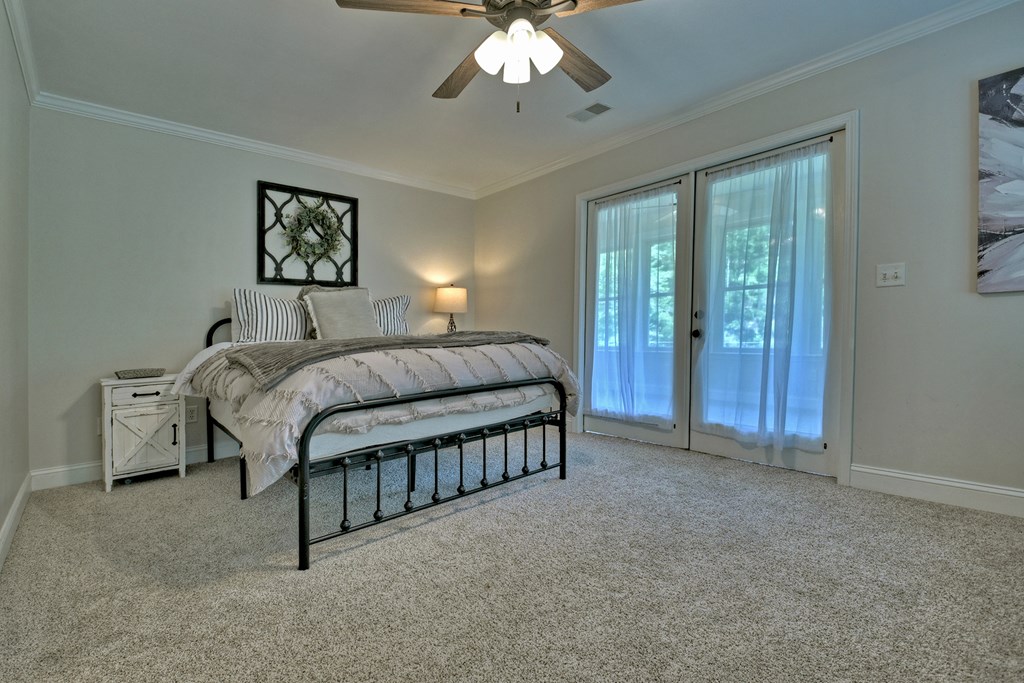 53 Addle Trail Ellijay, GA 30540 - Photo 25 of 50 a spacious bedroom with a bed a chandelier and a dresser