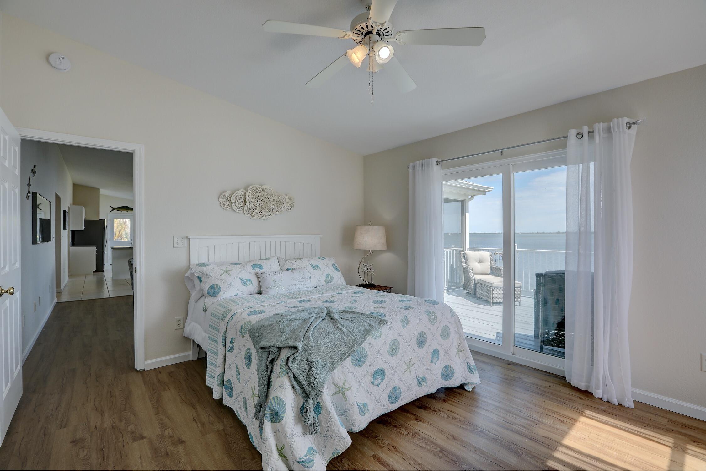 8825 Highway 1 Micco, FL 32976 - Photo 19 of 32 a bedroom with a large bed and a chandelier