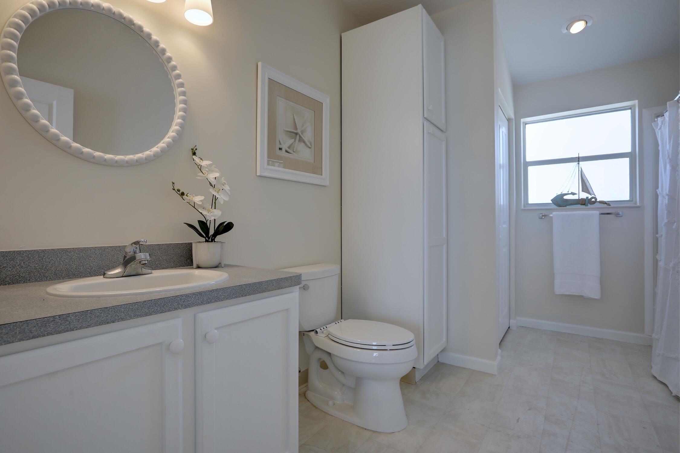 8825 Highway 1 Micco, FL 32976 - Photo 20 of 32 a bathroom with a granite countertop toilet a sink and mirror