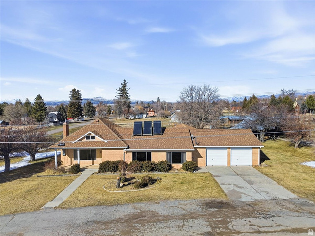 217 East 400 South Spring City, UT 84662 - Photo 45 of 71 Single story home with a front yard, roof mounted solar panels, concrete driveway, a chimney, and a shingled roof